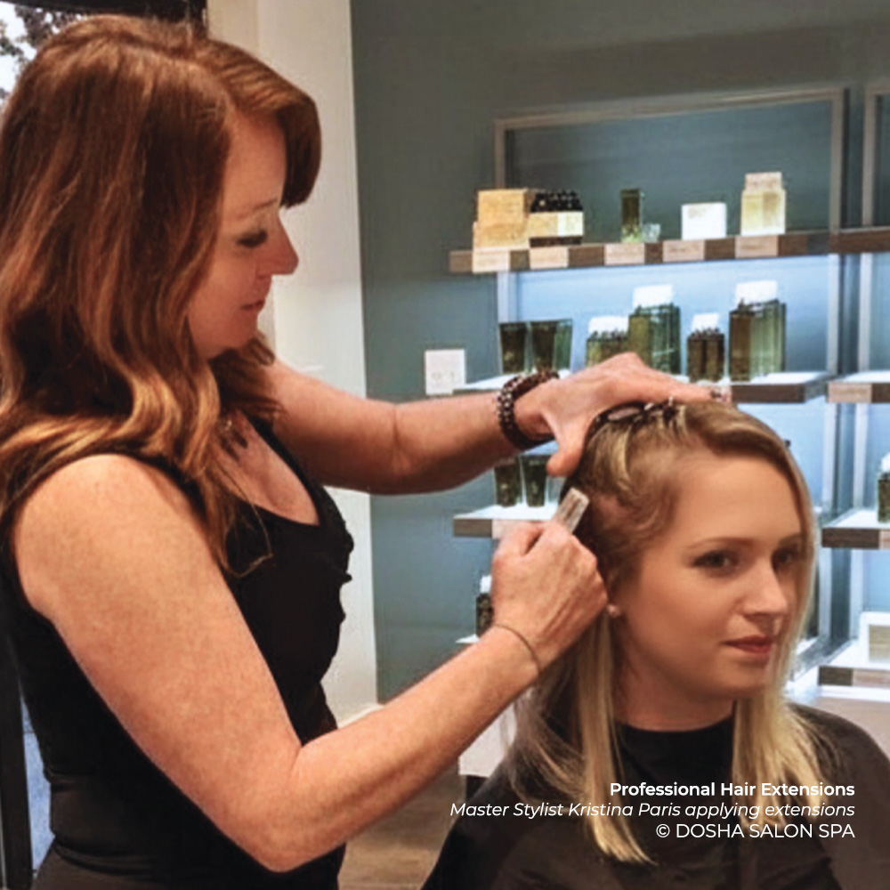 Master Stylist Kristina Paris applying hair extensions at Dosha Salon Spa.