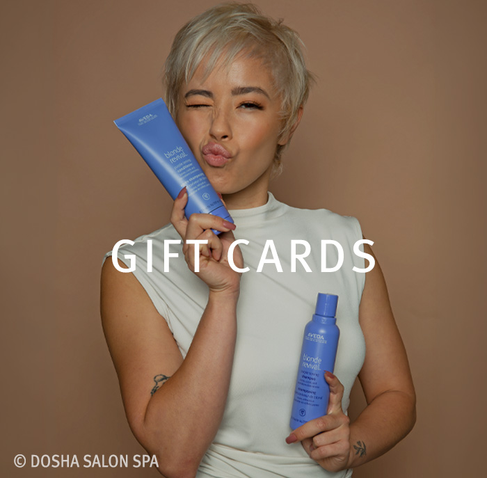 A Dosha guest holding Aveda products purchased with a gift card at Dosha Salon Spa