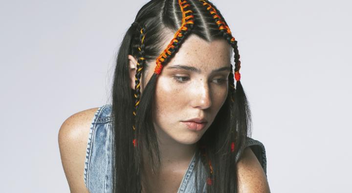 Image Braids x Denim photoshoot by Dosha Creative Team with a young woman with braids and color woven in and wearing a denim vest