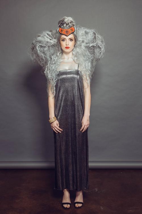 photoshoot of model posing with circus inspired elephant hair and makeup in grey dress and heels