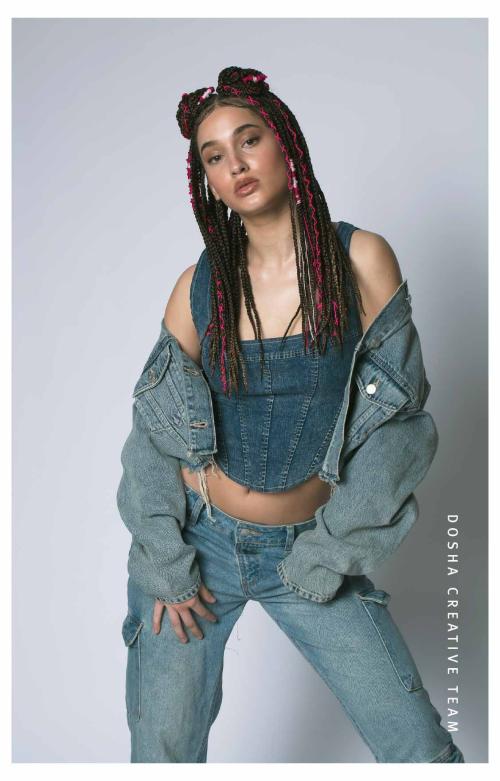 Image of Braids x Denim photoshoot by dosha creative team - a woman dressed in denim with her denim jacket down her shoulders with brown braids and red braids