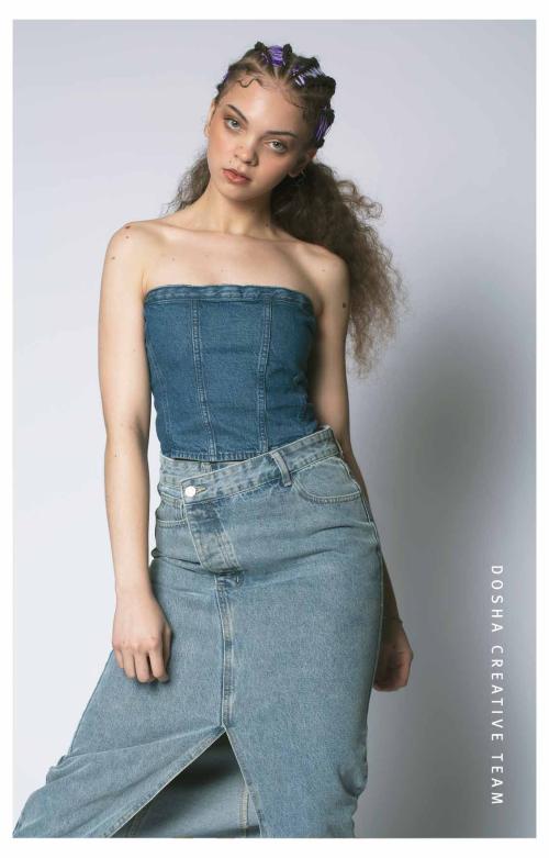 Braids x Denim photoshoot by Dosha Creative Team image of a young woman wearing a jean skirt and jean bodice with her hair in braids on top and the bottom curled out