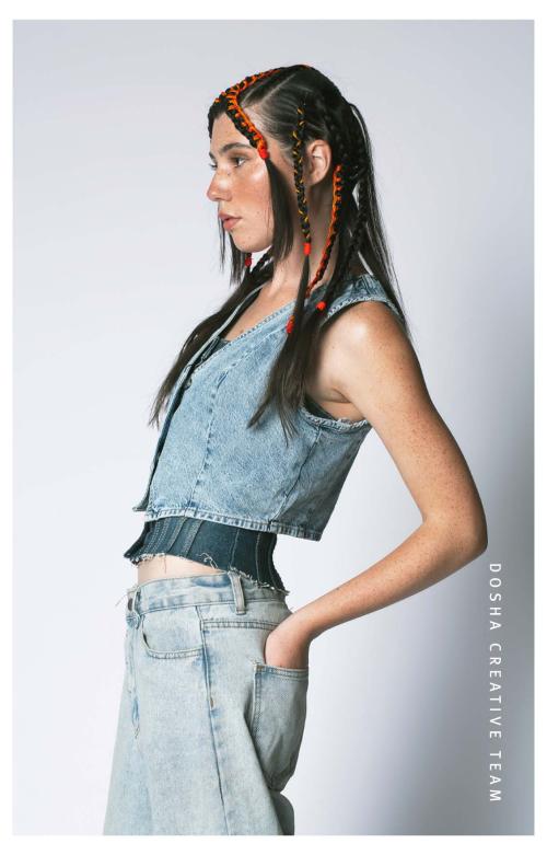 Braids x Denim photoshoot by Dosha Creative Team with a young woman wearing denim pants and a vest with her long hair braided with color