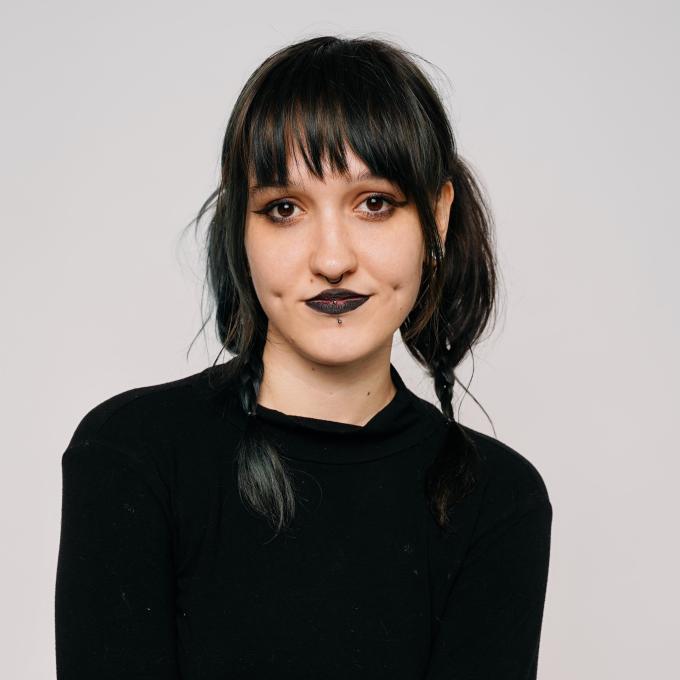 Stylist Megan with jet black hair in bubble pigtails and dark lips